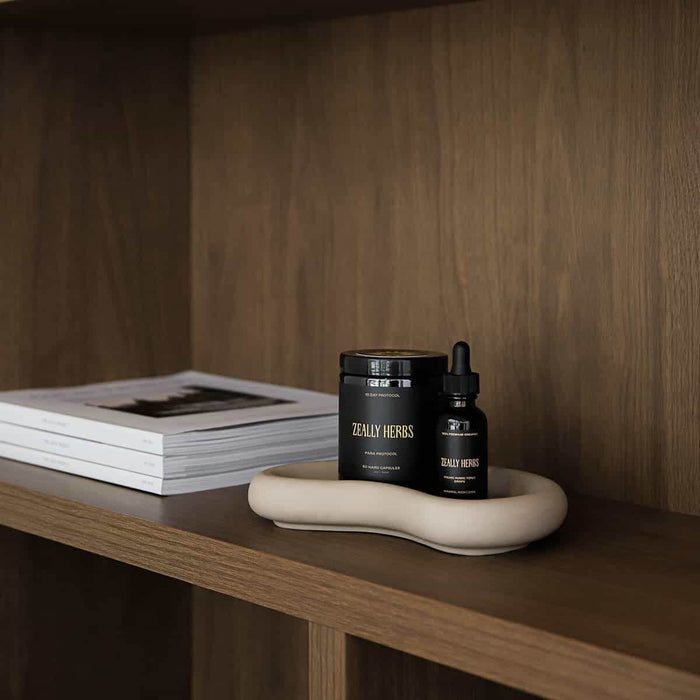 Para protocol & fulvic humic drops on a beige tray on a dark wooden shelving unit.