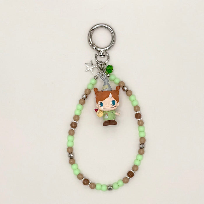 Keychain with beads and a small figurine on a light background