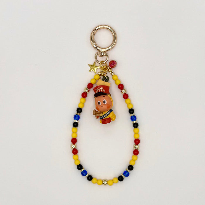 Colorful beaded keychain with a small figurine on a light gray background