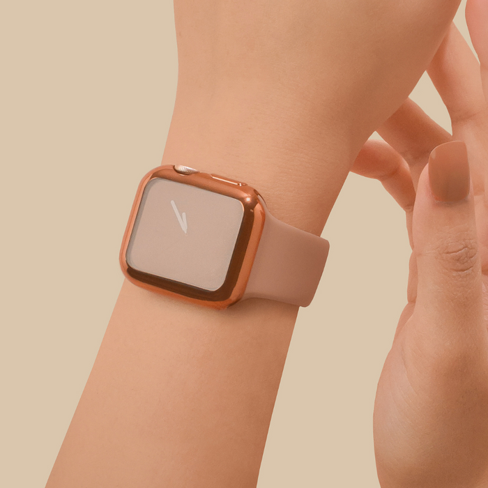 Rose gold metallic Apple Watch case with built-in screen protector and beige strap worn on wrist.