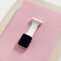 Coconut Lane Apple Watch clip-on fob strap in white with ditsy floral print, displayed on pink paper and glittery beige background.