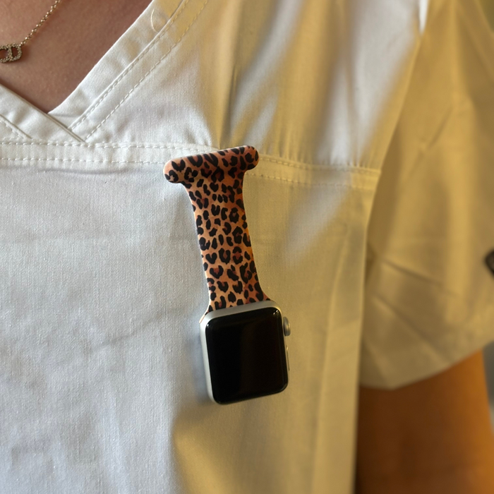 Leopard print clip-on fob strap for Apple Watch, attached to a shirt pocket.
