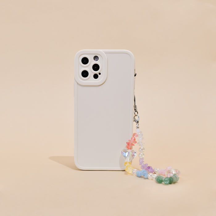 Beaded phone strap with colourful crystals attached to a white phone case on a beige surface.