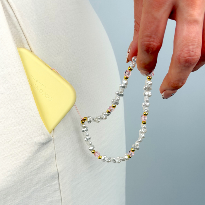 phone case in pocket with pearl gold and pink phone strap attached