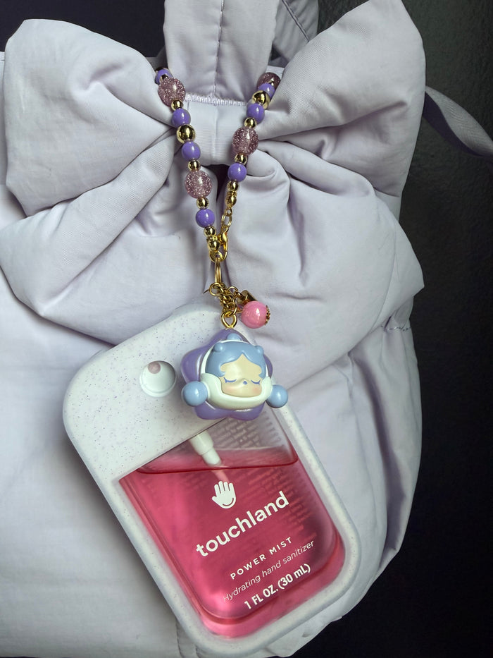Touchland Power Mist hand sanitizer in a white glitter silicone case on a white background. Attached gold lobster clasp keychain features a red-cloaked SP chibi charm with a round face, paired with a beaded wrist strap of alternating red and silver glitter beads with gold accent beads. TOUCHLAND NOT INCLUDED WITH THIS PRODUCT!
