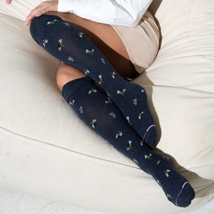 Knee-high compression socks with a navy background featuring bees and flowers design.