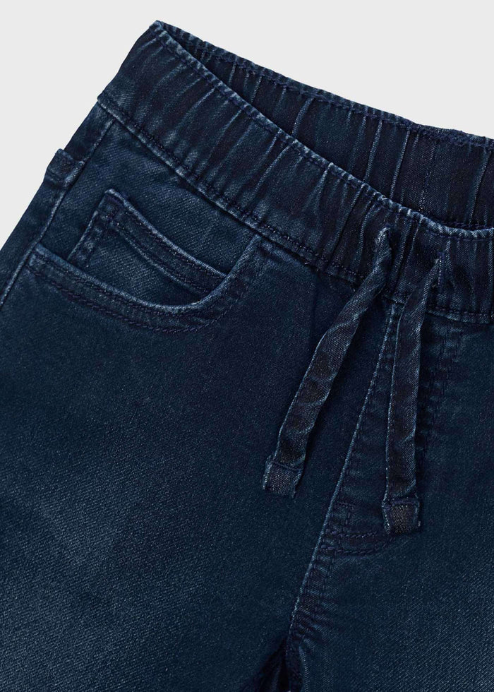 Close-up of Mayoral boys jeans showing elastic waist, drawstring-style detail, and dark denim fabric.