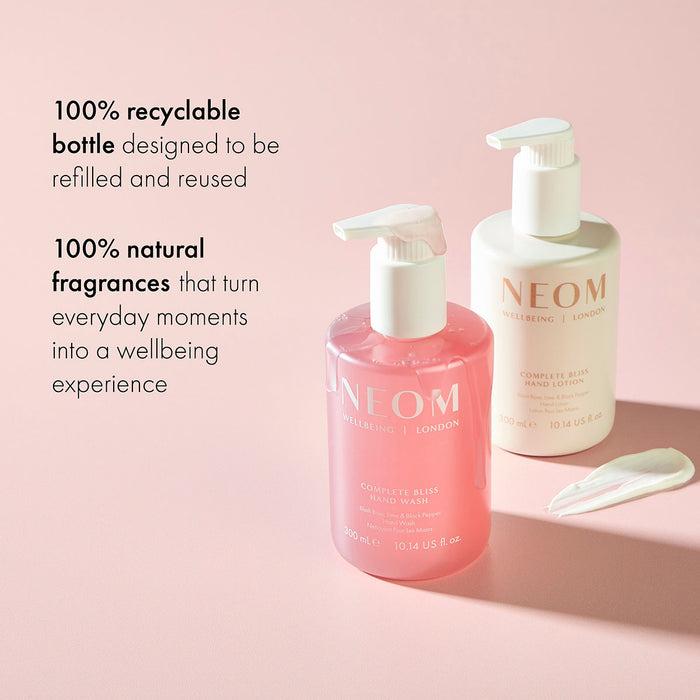 NEOM Complete Bliss hand wash and lotion bottles with recyclable packaging and natural fragrance messaging on pink background