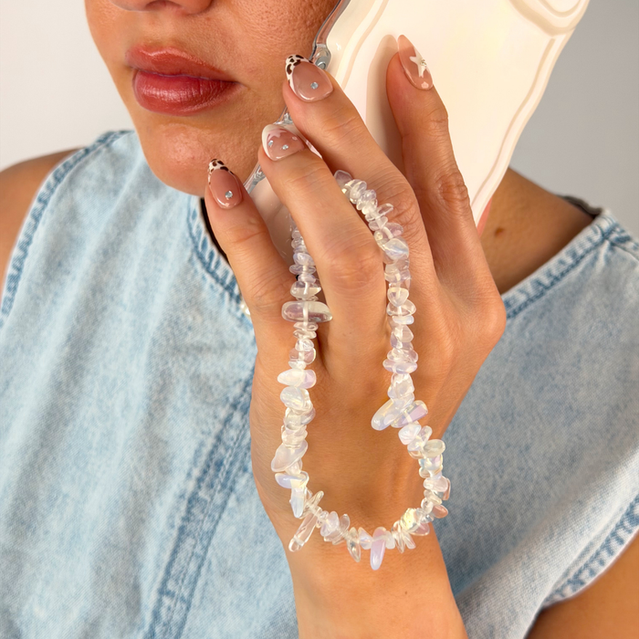 Girl on the phone holding her moonstone phone strap
