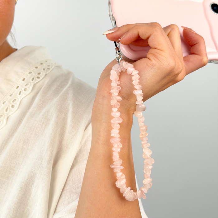 Girl with her rose quartz phone strap in a studio shoot