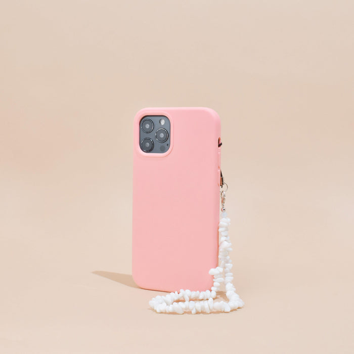 Pink smartphone case with clear Crystal Phone Strap stands upright against a beige background.