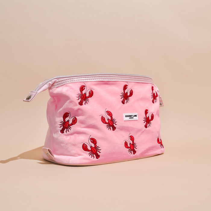 Pink velvet expandable makeup bag with a zipper, printed with playful red lobsters.