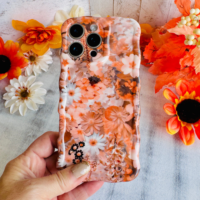 Fall Blooms Wavy Luxe MagSafe iPhone case with a warm autumn floral print in orange and cream from Fancy Bands