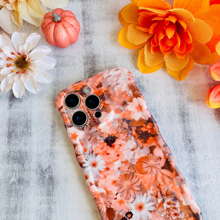Fall Blooms Wavy Luxe MagSafe iPhone case with a warm autumn floral print in orange and cream from Fancy Bands