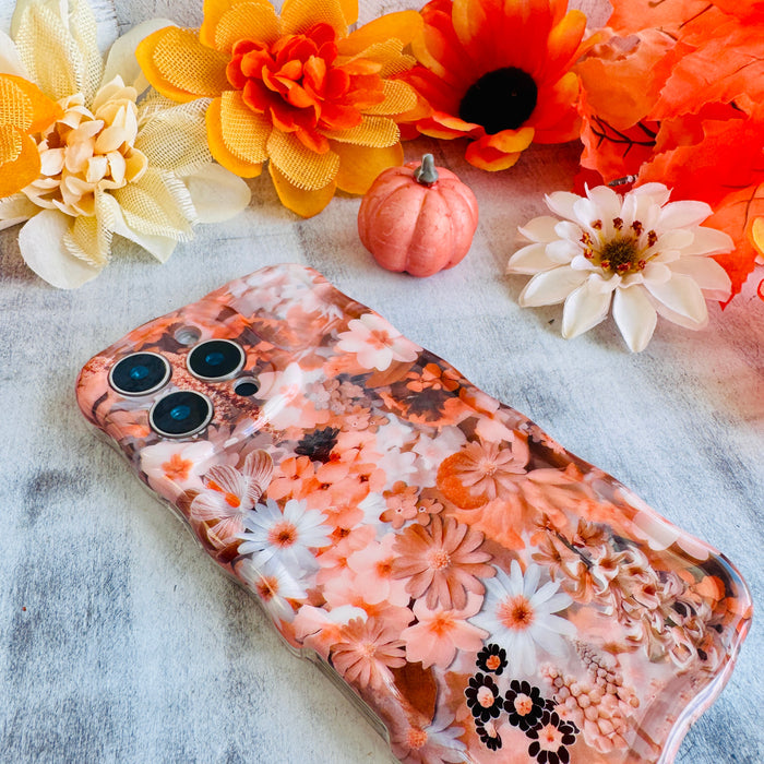 Fall Blooms Wavy Luxe MagSafe iPhone case with a warm autumn floral print in orange and cream from Fancy Bands