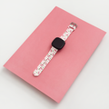 Coconut Lane Disco Cherries Fitbit strap with cherry pattern on white, displayed on a pink surface.