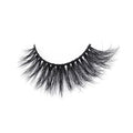 A single strip of dramatic, thick, black false eyelashes with a crisscross pattern is showcased on a white background for a bold and glamorous look.