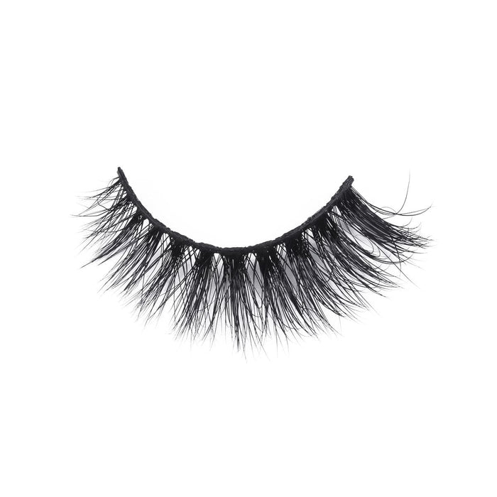 A single strip of dramatic, thick, and wispy false eyelashes with a black band on a plain white background for bold eye looks.