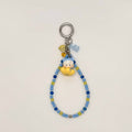 Keychain with beads and a small figure toy on a light gray background