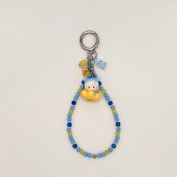 Keychain with beads and a small figure toy on a light gray background