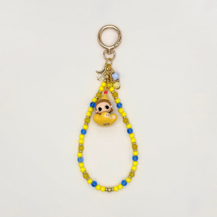 Colorful beaded keychain with a small character charm on a light gray background