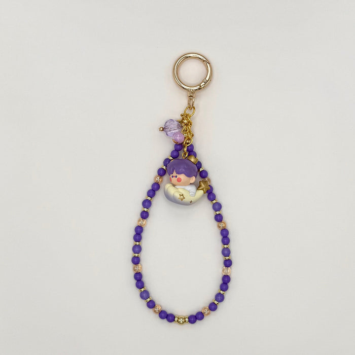 Keychain with beads and a small figure on a light gray background