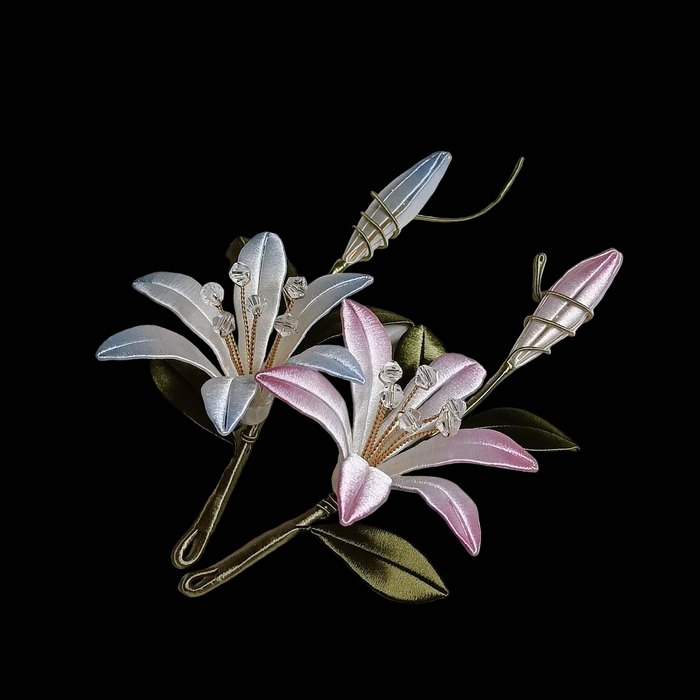 Handcrafted Chanhua brooch featuring a white lily and a pink daylily with coiled wire buds.