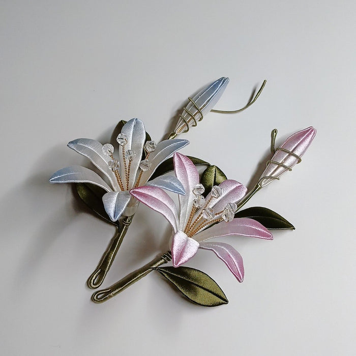 Top-down view of a traditional Chinese silk-wrapped (Chanhua) floral brooch on a plain background, showing intricate hand-wound thread details.