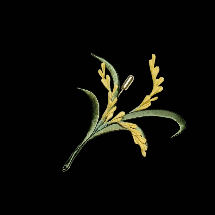A top-down view of a traditional Chinese silk-wrapped (Chanhua) brooch designed as a stem of ripe wheat, showcasing intricate hand-wound thread details.