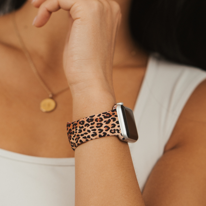 Coconut Lane leopard print Apple Watch strap, gold necklace, and white sleeveless top.