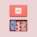 Set of three patterned socks in a box with 'milk shake' branding on a pink background.