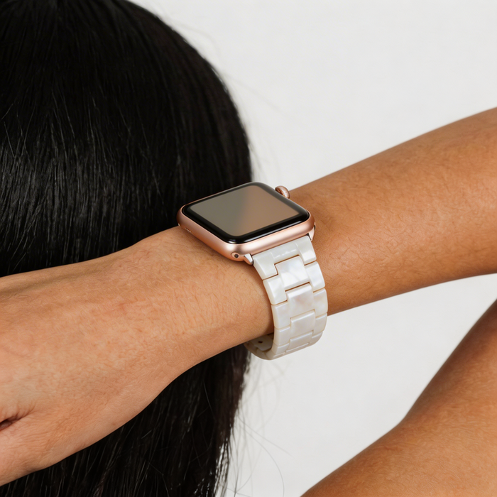 Coconut Lane Luxe Iridescent Apple Watch strap with a rose gold case on wrist, shown against a plain background.