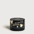 Black cylindrical portable diffuser with gold designs and text on a light gray background