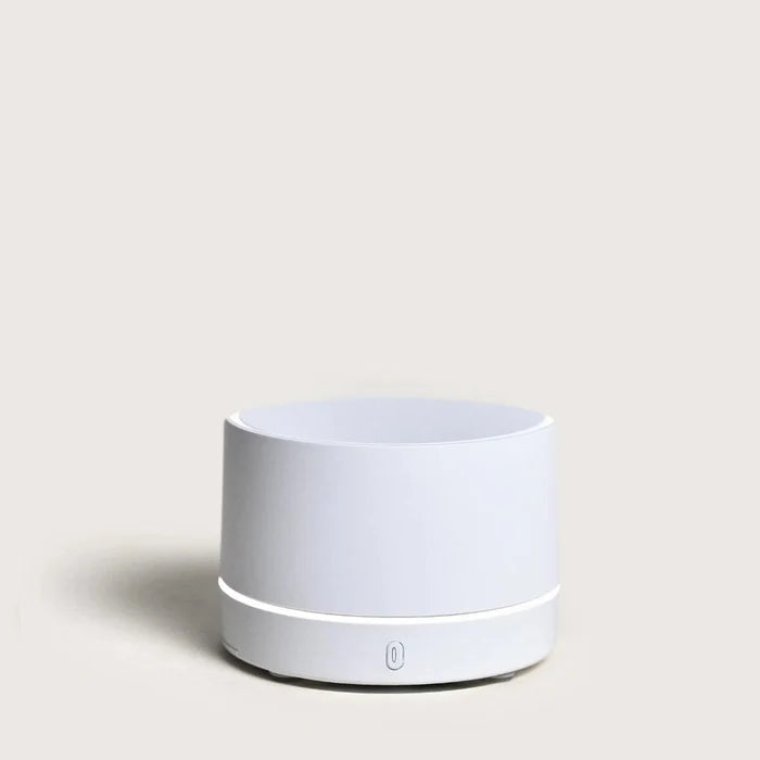 White cylindrical portable diffuser on a light gray background