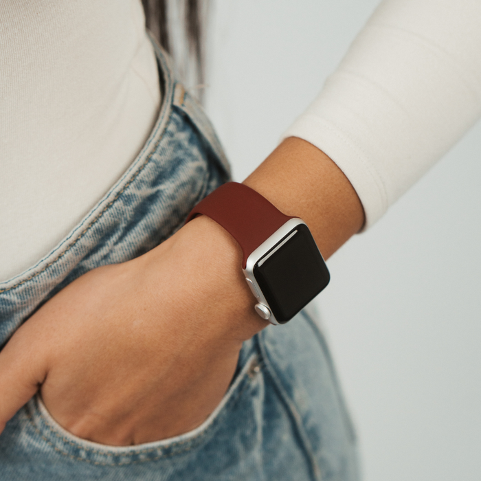 Burgundy Coconut Lane NAKD Apple Watch strap shown on wrist, hand in blue jean pocket.