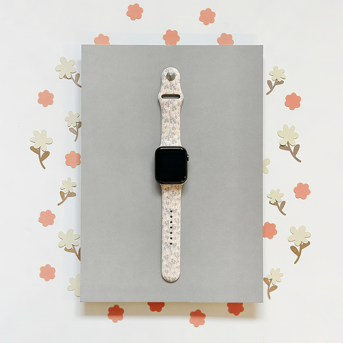 Gray Apple Watch strap with white floral pattern.