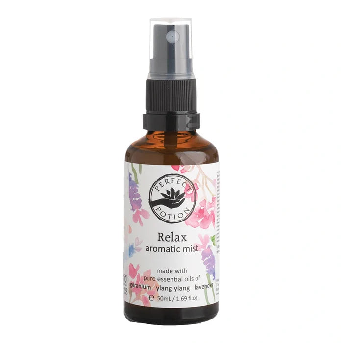 A 50ml amber glass spray bottle of Perfect Potion Relax Aromatic Mist, featuring a white label with pink and purple floral illustrations and a black spray nozzle, set against a plain white background.