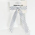 White polka dot ribbon bow hair clip on Coconut Lane branded packaging.