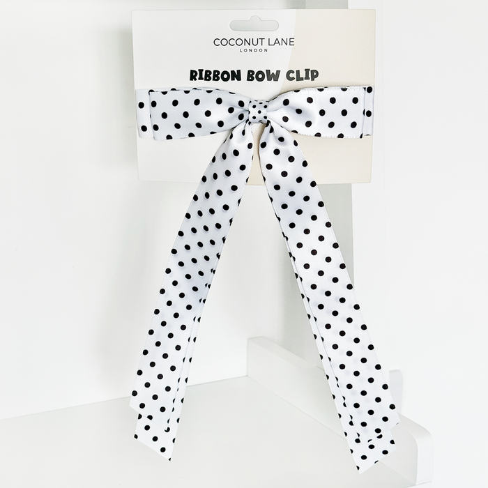 White polka dot ribbon bow hair clip on Coconut Lane branded packaging.