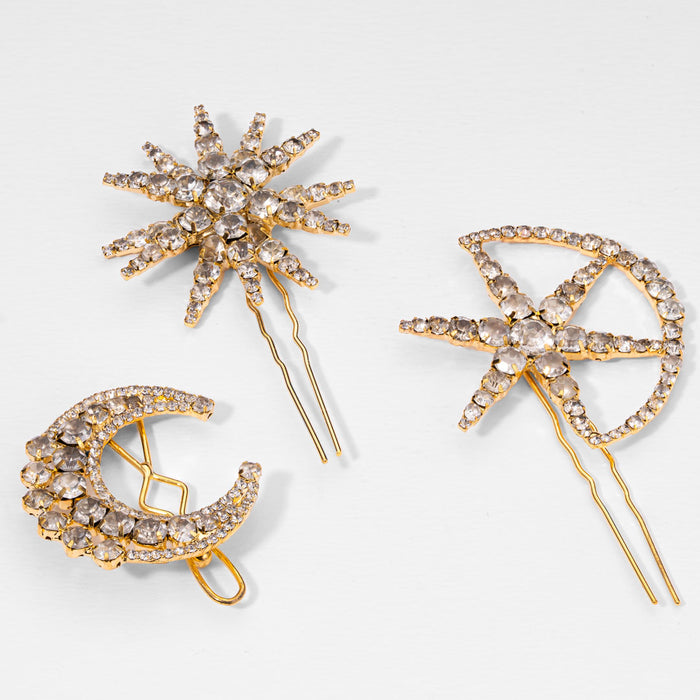 Three gold hairpins with star, moon, and bow designs on a light gray background