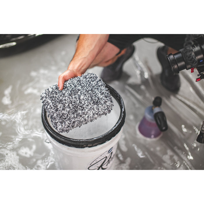 Black and White wash pad held over a cleaning solution