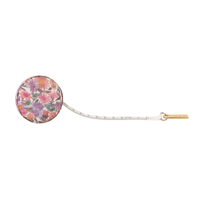 Round floral tape measure against a white background