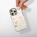 Hand holding a Coconut Lane Tough Phone Case with playful chicken, cow, and sheep illustrations on a white background.