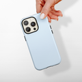 Hand holding a baby blue Coconut Lane Tough phone case against a white background.