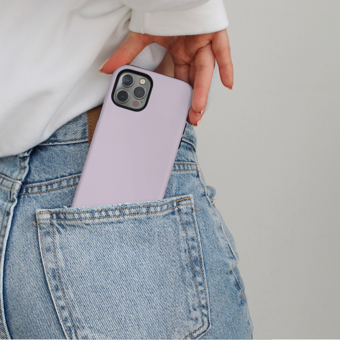 Person in jeans sliding a lilac Coconut Lane Tough Phone Case into their back pocket.