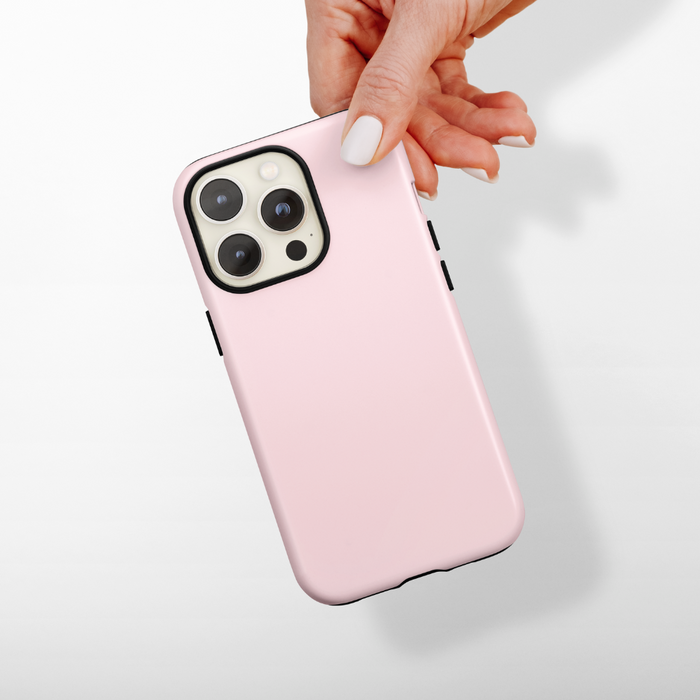 Hand with white nails holds a pink Coconut Lane Tough Phone Case against a plain white background.