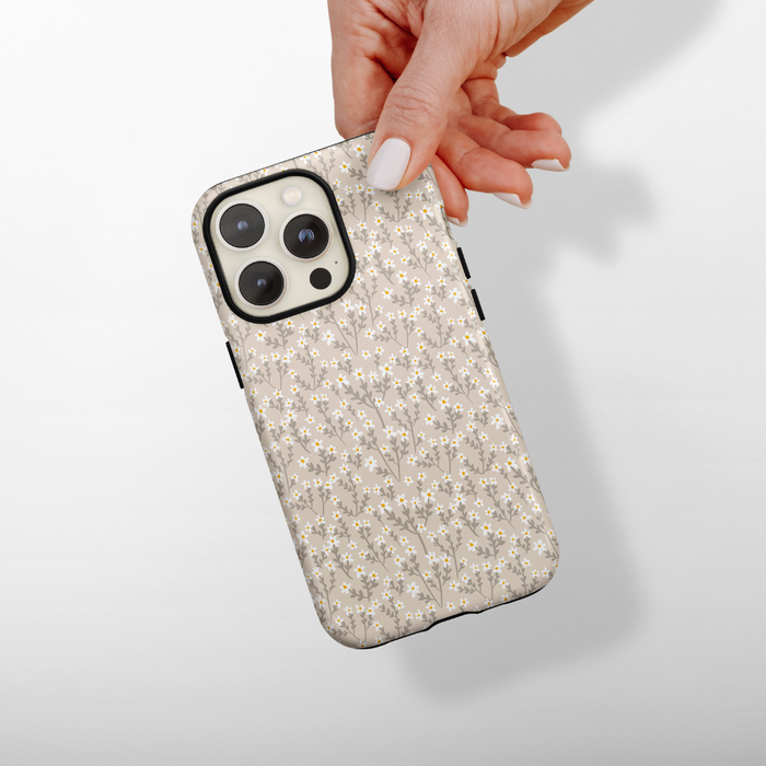 Hand holding a nude floral Tough MagSafe® phone case with Coconut Lane branding against a light background.