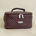 Brown and blue polka dot vanity case with zipper closure and top handle.