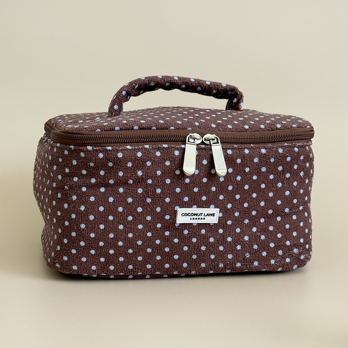 Brown and blue polka dot vanity case with zipper closure and top handle.