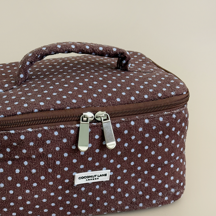 Brown and blue polka dot travel towel vanity case by Coconut Lane on a beige background.